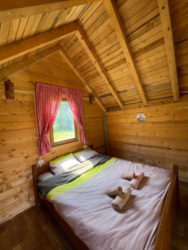 a bed in a log cabin with a window at ABBA Ethno House in Gusinje