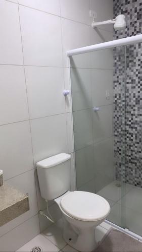 a bathroom with a toilet and a glass shower at Apartamento 3 min do FIG in Garanhuns