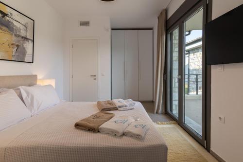 a bedroom with a bed with towels on it at Olive Residence in Skala Fourkas