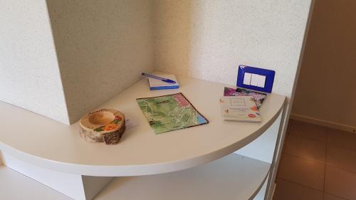 a white counter with books and pamphlets on it at La Finestra Sul Lago in Cernobbio