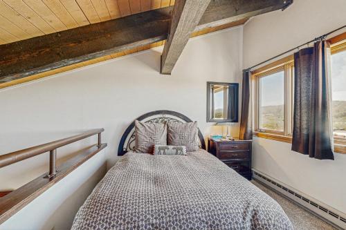 a bedroom with a bed in a room with windows at Emerald Views at the West in Steamboat Springs