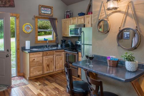 a kitchen with wooden cabinets and a counter with glasses of wine at Eureka Sunset Cabins in Eureka Springs