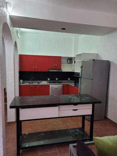 a kitchen with red cabinets and a stainless steel refrigerator at Villa Tiguert Luxury in Tiguert