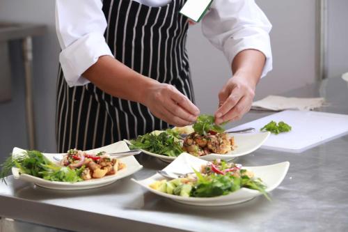 a chef preparing plates of food on a counter at Villa Isla Azul in Ocotal
