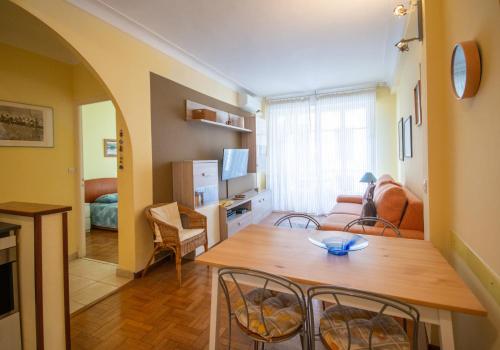 un salon avec une table et des chaises en bois dans l'établissement Joli 2 pièces climatisé à 150m de la plage, à Nice