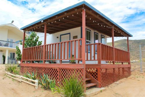 a house with a large deck in the desert at Lirios Tiny House en Valle de Guadalupe in Valle de Guadalupe