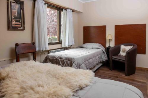 a bedroom with two beds and a large white rug at Hotel Le Charme in San Carlos de Bariloche