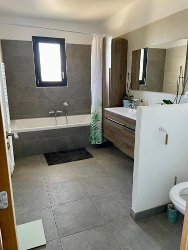 une salle de bain avec une baignoire, des toilettes et un lavabo dans l'établissement Villa Eden, à Saint-Drézéry