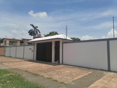 a dog sitting in front of a white building at Stella by Türk in Chetumal