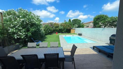 un patio avec une table et des chaises à côté d'une piscine dans l'établissement Villa Eden, à Saint-Drézéry