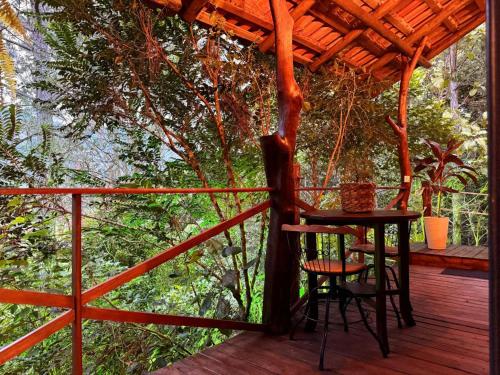 a wooden deck with a table and two chairs on it at Chalé Matas de Camboriú in Camboriú