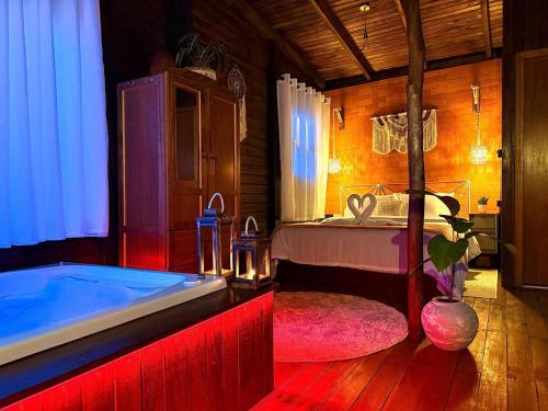a bedroom with a bed and a bath tub at Chalé Matas de Camboriú in Camboriú