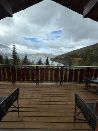 a deck with benches and a view of a lake at Maxi Cabin with Sauna and Jacuzzi in Kovan