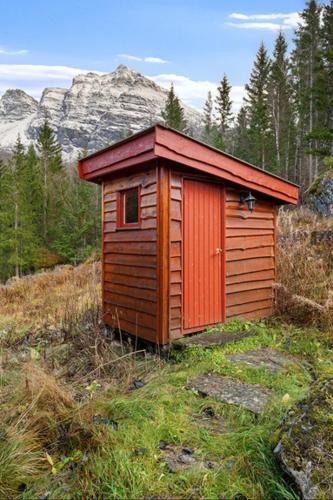 a wooden out house in the middle of a field at Maxi Cabin with Sauna and Jacuzzi in Kovan