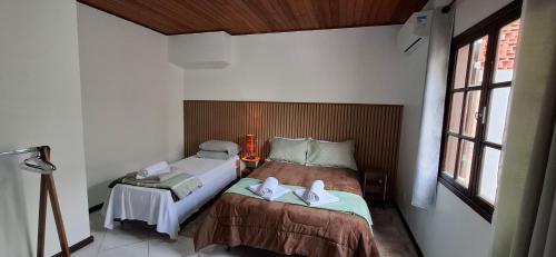a small bedroom with two beds and a window at Casa Ouro Preto in Ouro Preto