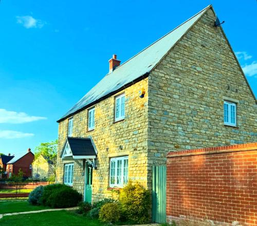 an old brick house with a brick wall at Silverstone Paddock Retreat in Silverstone