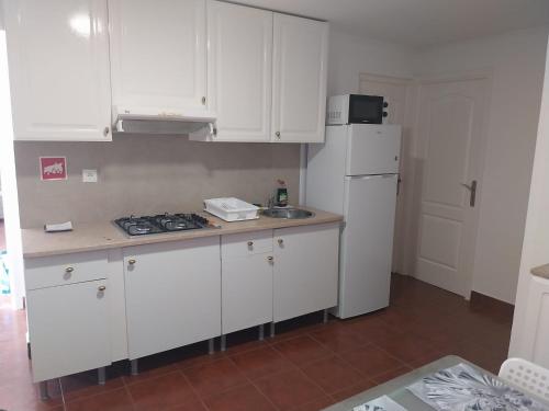 a kitchen with white cabinets and a white refrigerator at Casa Santa Maria apartamento B in Ermidas