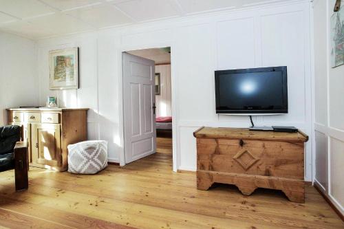 a living room with a flat screen tv on a wall at Grosshus Vals in Vals