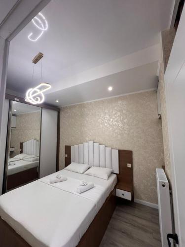 Un dormitorio con una cama grande y un espejo. en New comfort class apartments, en Kutaisi