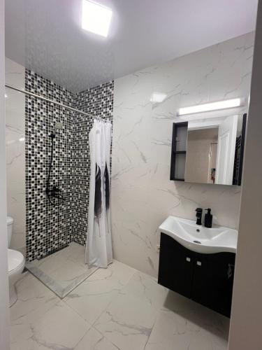 un baño con ducha y lavabo en New comfort class apartments, en Kutaisi