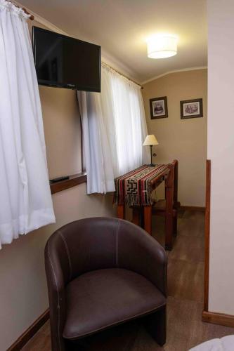 a living room with a chair and a table at Hotel Le Charme in San Carlos de Bariloche