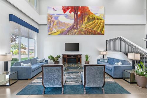 a living room with blue couches and a tv at Best Western Plus Washington Hotel in Washington