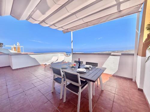 a table and chairs on a balcony with a view of the ocean at Ocean View Haven, Perla Del Mar in Adeje
