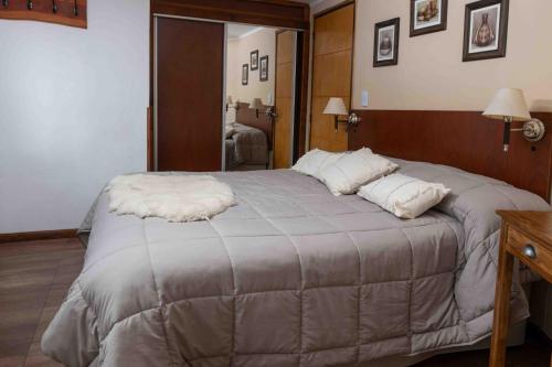 a large bed in a bedroom with a mirror at Hotel Le Charme in San Carlos de Bariloche