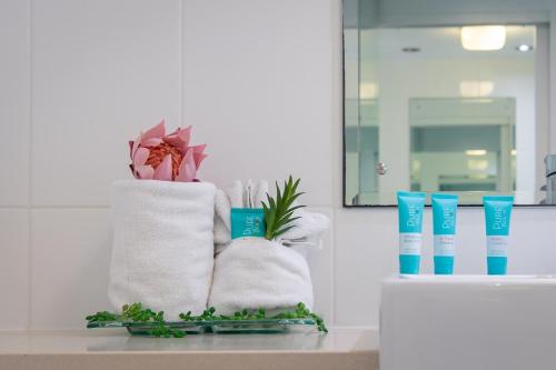 un lavabo con toallas y plantas en una encimera en Spectacular Seaviews, Pool, Modern, Free Wifi, en Airlie Beach