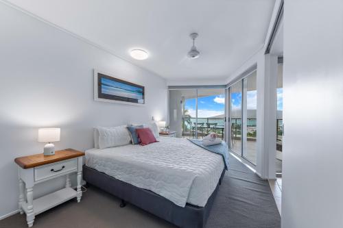 Un dormitorio con una cama y una ventana grande. en Spectacular Seaviews, Pool, Modern, Free Wifi, en Airlie Beach