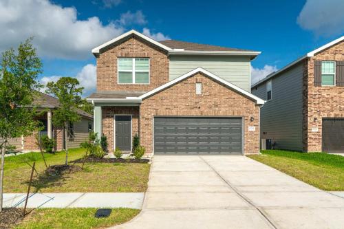 a brick house with a garage at Pool house with hot tub in Houston