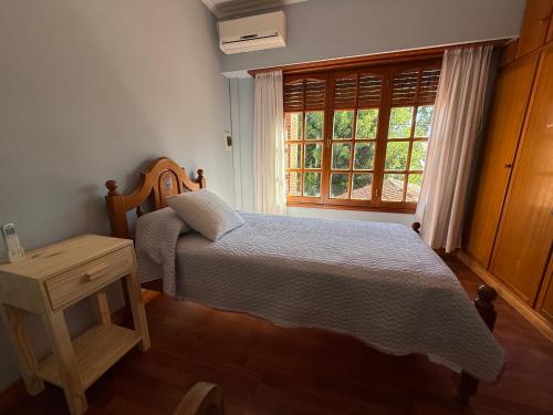 ein Schlafzimmer mit einem Bett und einem Fenster in der Unterkunft Casa del Bicentenario in Tandil