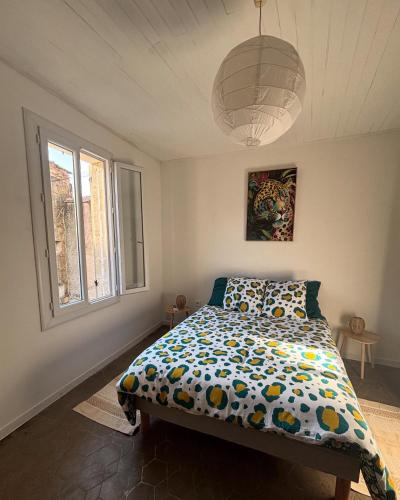 a bedroom with a bed and a large window at Écrin paisible in Vergèze