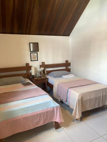 a room with two beds and a table in a room at Condomínio Serra Nevada - Chalé 202 in Bananeiras