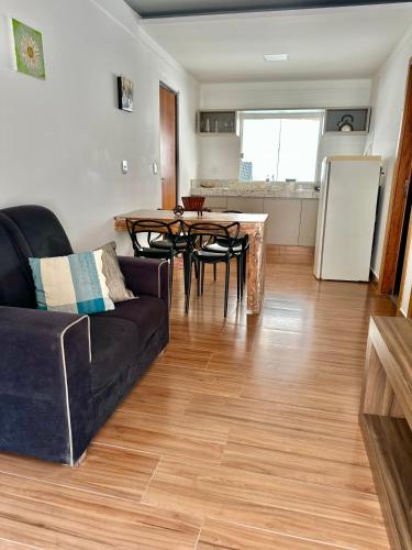 a living room with a couch and a table at Flat com Jacuzzi - Cantinho do Lago 2 in Capitólio