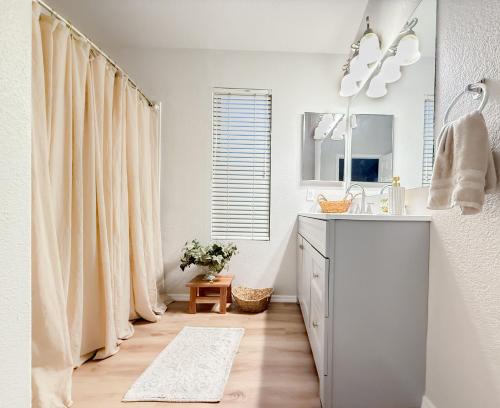 a white bathroom with a sink and a mirror at Cactus Bonito in Phoenix