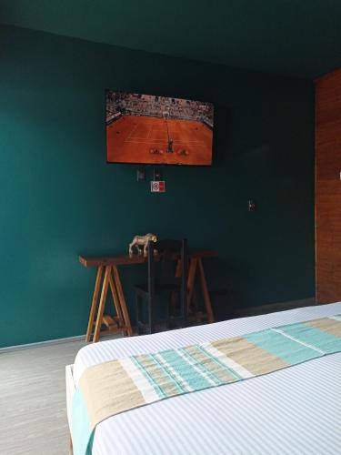 a bedroom with a table and a tv on the wall at Hotel Momotus Tuxtla - Desayuno opcional in Tuxtla Gutiérrez