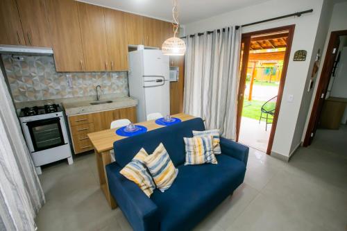 a living room with a blue couch and a kitchen at Casa_Mare11 in São Miguel do Gostoso