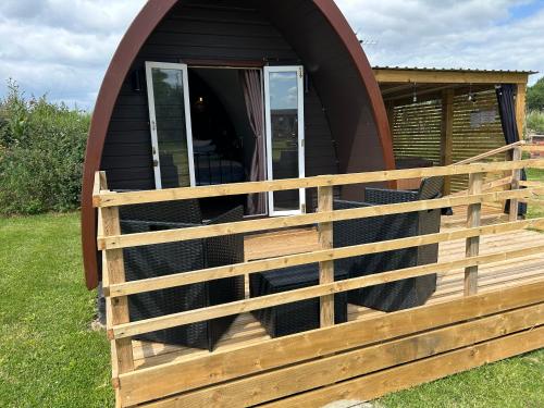 a cabin with a wooden fence around it at Dolafon Luxury Glamping Pod 2 With Hot Tub in St Asaph