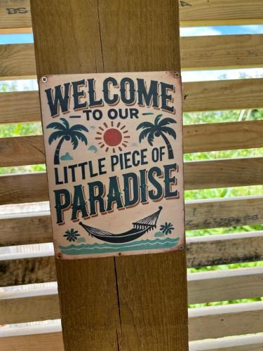 a sign on a pole that says welcome to our little piece of paradise at Dolafon Luxury Glamping Pod 2 With Hot Tub in St Asaph