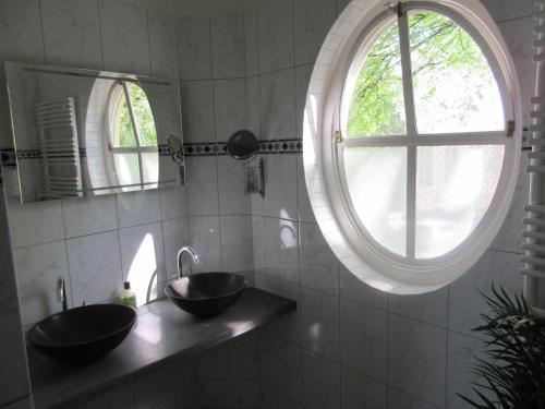 Un baño con dos lavabos y una gran ventana. en Guesthouse Groenmarkt, en Middelburg