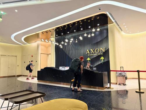 a man walking in a lobby with a store at GriffinS Grove at Axon Residence Bukit Bintang in Kuala Lumpur