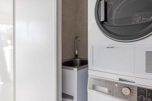a kitchen with a sink and a microwave at Mantra French Quarter Noosa in Noosa Heads