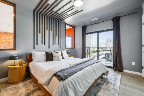 Un dormitorio con una cama grande y una ventana grande. en The Rhythm and Rooftop Penthouse Walk To Broadway with Pool and Amazing Views, en Nashville