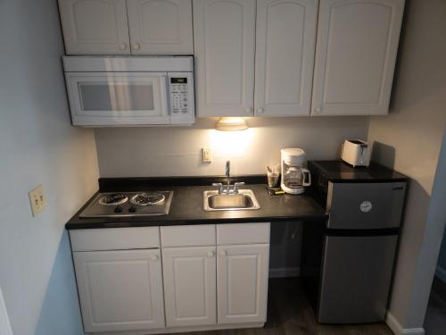 a small kitchen with a sink and a microwave at Ships Inn in Hampton
