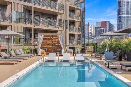 a swimming pool with lounge chairs and a building at The Rhythm and Rooftop Penthouse Walk To Broadway with Pool and Amazing Views in Nashville
