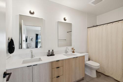 a bathroom with a sink and a toilet and a mirror at Skyline Nights in Downtown Nashville Walk to Broadway with Pool and Gym in Nashville