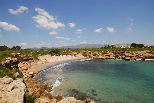 a beach with a group of people in the water at CALA FORN y CLIMATIZADA in Les tres Cales