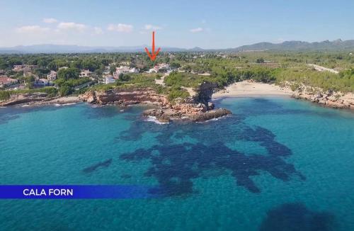 an aerial view of a small island in the ocean at CALA FORN y CLIMATIZADA in Les tres Cales