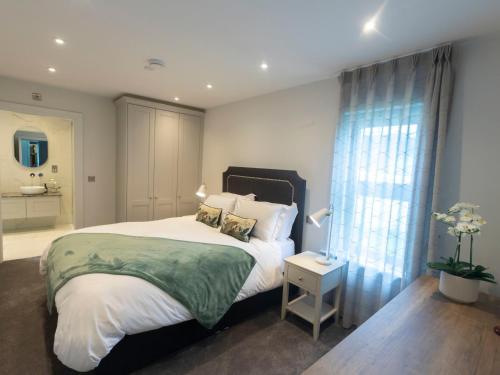 a bedroom with a large bed and a bathroom at The Forest at Mount Congreve Gardens in Kilmeaden
